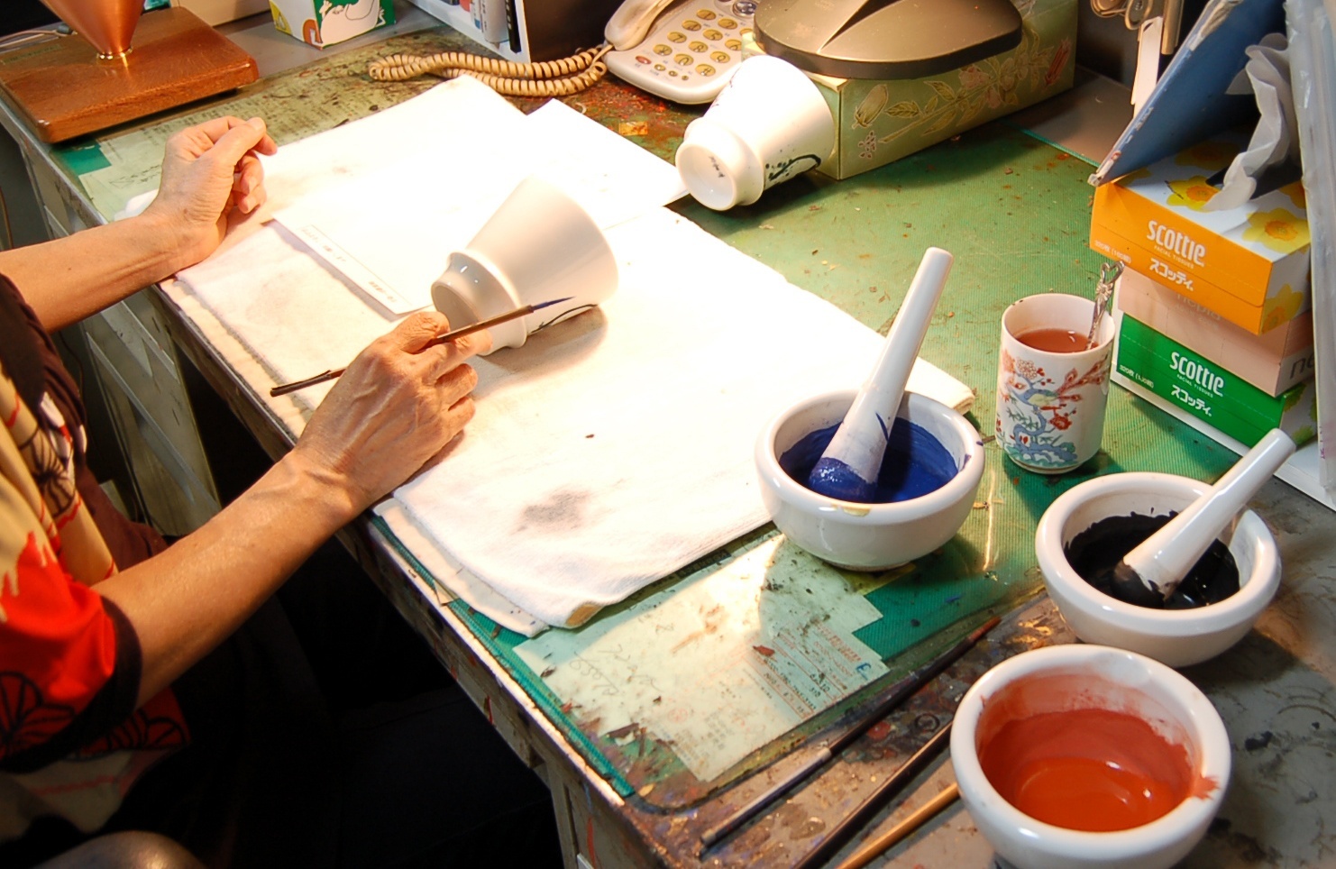 赤絵の絵付け職人が作業をしている手元